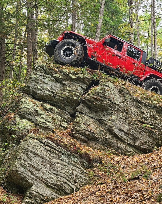 Red Jeep Gladiator perched on King's Rock at Three Ridges Events OffRoad Park in Hinsdale, NH